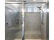 Shower featuring gray tiles, glass doors, rain shower head, and bench seating at 6346 Rock Strm Ln, Las Vegas, NV 89141