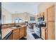 Functional kitchen with an opening to the living room, light wood cabinets, and stainless steel appliances at 6637 Lookout Lodge Ln # 1, North Las Vegas, NV 89084