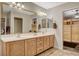 Bright bathroom with double sinks, ample storage in wood cabinets, and decorative mirrors at 6828 Sumatra St, Las Vegas, NV 89166