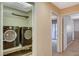 Convenient laundry room featuring modern, black washer and dryer, plus shelving for storage at 6828 Sumatra St, Las Vegas, NV 89166