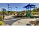 Community playground featuring a climbing wall and multiple slides under a blue shade structure at 6828 Sumatra St, Las Vegas, NV 89166
