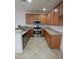 Well-lit kitchen featuring wooden cabinets, stainless steel appliances, and tile flooring at 684 Calamus Palm Pl, Henderson, NV 89011