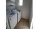 Laundry room featuring a washer and dryer, shelving, and tile flooring at 684 Calamus Palm Pl, Henderson, NV 89011