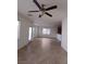 Spacious living room featuring tile flooring, a ceiling fan, and bright windows at 684 Calamus Palm Pl, Henderson, NV 89011
