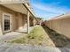 View of the home's private backyard with a covered patio, small grass yard, and stucco fence at 6913 Mill Creek Way, Las Vegas, NV 89149