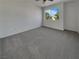 Bright, carpeted bedroom with a large window offering neighborhood views and ample natural light at 6913 Mill Creek Way, Las Vegas, NV 89149