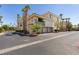 Condo building exterior featuring private garages, lush landscaping, and a well-maintained community at 7151 S Durango Dr # 211, Las Vegas, NV 89113