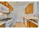 Charming kitchen with white appliances complemented by oak cabinets at 7151 S Durango Dr # 211, Las Vegas, NV 89113