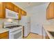 Well-lit kitchen with white appliances and warm-toned wooden cabinets at 7151 S Durango Dr # 211, Las Vegas, NV 89113
