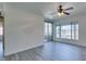 Bright living area featuring gray flooring, a large window, and sliding glass doors to a balcony at 7151 S Durango Dr # 211, Las Vegas, NV 89113