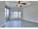 Well-lit living room boasting stylish ceiling fan, gray flooring, and access to a private balcony at 7151 S Durango Dr # 211, Las Vegas, NV 89113
