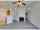 Open floor plan featuring gray wood floors, fireplace, and a ceiling fan at 7151 S Durango Dr # 211, Las Vegas, NV 89113