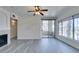 Bright living room featuring gray wood floors, ceiling fan, and fireplace at 7151 S Durango Dr # 211, Las Vegas, NV 89113