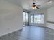 Spacious living room with wood-look floors, ample natural light, and access to a private balcony at 7151 S Durango Dr # 211, Las Vegas, NV 89113