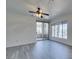 Living room area with wood-look floors, large windows, and sliding glass doors to a balcony at 7151 S Durango Dr # 211, Las Vegas, NV 89113