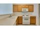 Bright kitchen features oak cabinets, white appliances, and a double sink at 7163 S Durango Dr # 302, Las Vegas, NV 89113