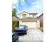 Two-story home with a large two-car garage door and classic desert landscaping at 7640 Highland Pony St, Las Vegas, NV 89149