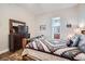 Cozy bedroom with decorative quilt, tiled floor, dresser and TV; view of ensuite bathroom at 7711 Gracemoor Ct, Las Vegas, NV 89149