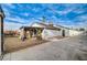 Exterior view showcasing the back of the house and a covered patio with spacious gravel yard and mature trees at 806 Fireweed Dr, Henderson, NV 89002