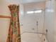 Bathroom with a floral shower curtain and white tiled walls at 806 Fireweed Dr, Henderson, NV 89002
