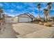 Single-story home boasts a desert landscape with palm trees and spacious driveway at 806 Fireweed Dr, Henderson, NV 89002