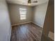 Bright bedroom with wood-look flooring, neutral walls, and a window at 8105 Switchback Run St, Las Vegas, NV 89166