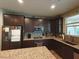 Well-equipped kitchen featuring dark cabinetry, granite countertops, and stainless steel appliances at 8105 Switchback Run St, Las Vegas, NV 89166
