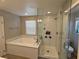 Well-lit primary bathroom featuring a large soaking tub and a glass shower at 8105 Switchback Run St, Las Vegas, NV 89166
