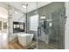 Elegant bathroom featuring a glass-enclosed shower, soaking tub, and marble accents at 8305 Woodland Prairie Ave, Las Vegas, NV 89129