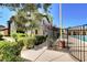 A beige two-story home with mature landscaping and walkway near community pool and greenery at 8324 W Charleston Blvd # 2053, Las Vegas, NV 89117