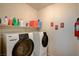 Close-up view of a modern washer and dryer set in a well-lit laundry room with storage shelves at 8324 W Charleston Blvd # 2053, Las Vegas, NV 89117