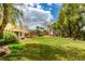Spacious backyard with a lush green lawn, mature trees, and a play area, ideal for recreation and relaxation at 8346 Christinas Cove Ave, Las Vegas, NV 89131