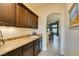 Elegant bar area with brown cabinets, granite counters, sink, and under-cabinet lighting at 8346 Christinas Cove Ave, Las Vegas, NV 89131