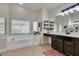 Bright bathroom featuring a soaking tub, a vanity with dark wood cabinets, and natural light at 8346 Christinas Cove Ave, Las Vegas, NV 89131