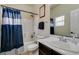 Bright bathroom featuring a shower-tub combination with a blue striped shower curtain and modern fixtures at 8346 Christinas Cove Ave, Las Vegas, NV 89131