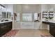Bright bathroom with dual sinks, a soaking tub, and tiled floors, providing a luxurious and functional space at 8346 Christinas Cove Ave, Las Vegas, NV 89131