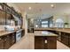 Beautiful kitchen featuring dark cabinets, granite countertops, stainless appliances, and a stone fireplace backdrop at 8346 Christinas Cove Ave, Las Vegas, NV 89131