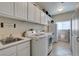 Efficient laundry room with a sink, modern washer and dryer, and ample storage cabinets at 8346 Christinas Cove Ave, Las Vegas, NV 89131