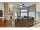 Bright living room featuring a stone fireplace, fan, wood floors, and inviting view of the backyard at 8346 Christinas Cove Ave, Las Vegas, NV 89131