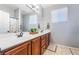 Bright bathroom features double sink vanity with granite countertop, wood cabinets, large mirror, and walk-in shower at 8817 Adobe Grande St, Las Vegas, NV 89131