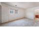 Well-lit bedroom with neutral carpet, a large window, and a door to a bathroom, offering convenience and comfort at 8872 Perfect Diamond Ct, Las Vegas, NV 89129
