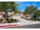 Street view of beige two-story home with mature trees and landscaping on a sunny day at 8872 Perfect Diamond Ct, Las Vegas, NV 89129