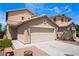 Beige two-story home featuring a two-car garage, desert landscaping, and a welcoming front entrance at 8872 Perfect Diamond Ct, Las Vegas, NV 89129