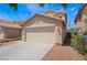 Beige two-car garage featuring a driveway and desert landscaping at 8872 Perfect Diamond Ct, Las Vegas, NV 89129