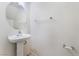 Bright powder room with a pedestal sink, a modern faucet and a round mirror providing a clean and simple design at 8872 Perfect Diamond Ct, Las Vegas, NV 89129