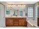 Lovely bathroom featuring double sinks, a soaking tub, and a mirrored wall at 9416 Highview Rock Ct, Las Vegas, NV 89149