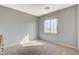 Sunlit bedroom with neutral walls, carpet, and a large window offering neighborhood views at 9416 Highview Rock Ct, Las Vegas, NV 89149
