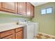 The laundry room includes upper cabinets, a window, and a washer and dryer at 9416 Highview Rock Ct, Las Vegas, NV 89149