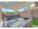 Backyard hot tub with clear blue water under a covered patio, set against a sunny sky and green lawn at 943 Sedona Rd, Henderson, NV 89014