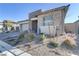 View of front of modern home with stone details and desert-friendly landscaping at 964 Norwood Heights Ln, Las Vegas, NV 89138